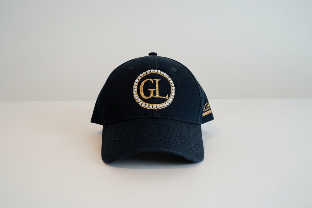 GL Cap Glam Luxe Hockey™ Cap featuring double gold glitter rings with rhinestone crystals, large GL monogram in glitter gold, and Glam Luxe with hockey stick detail — black cap
