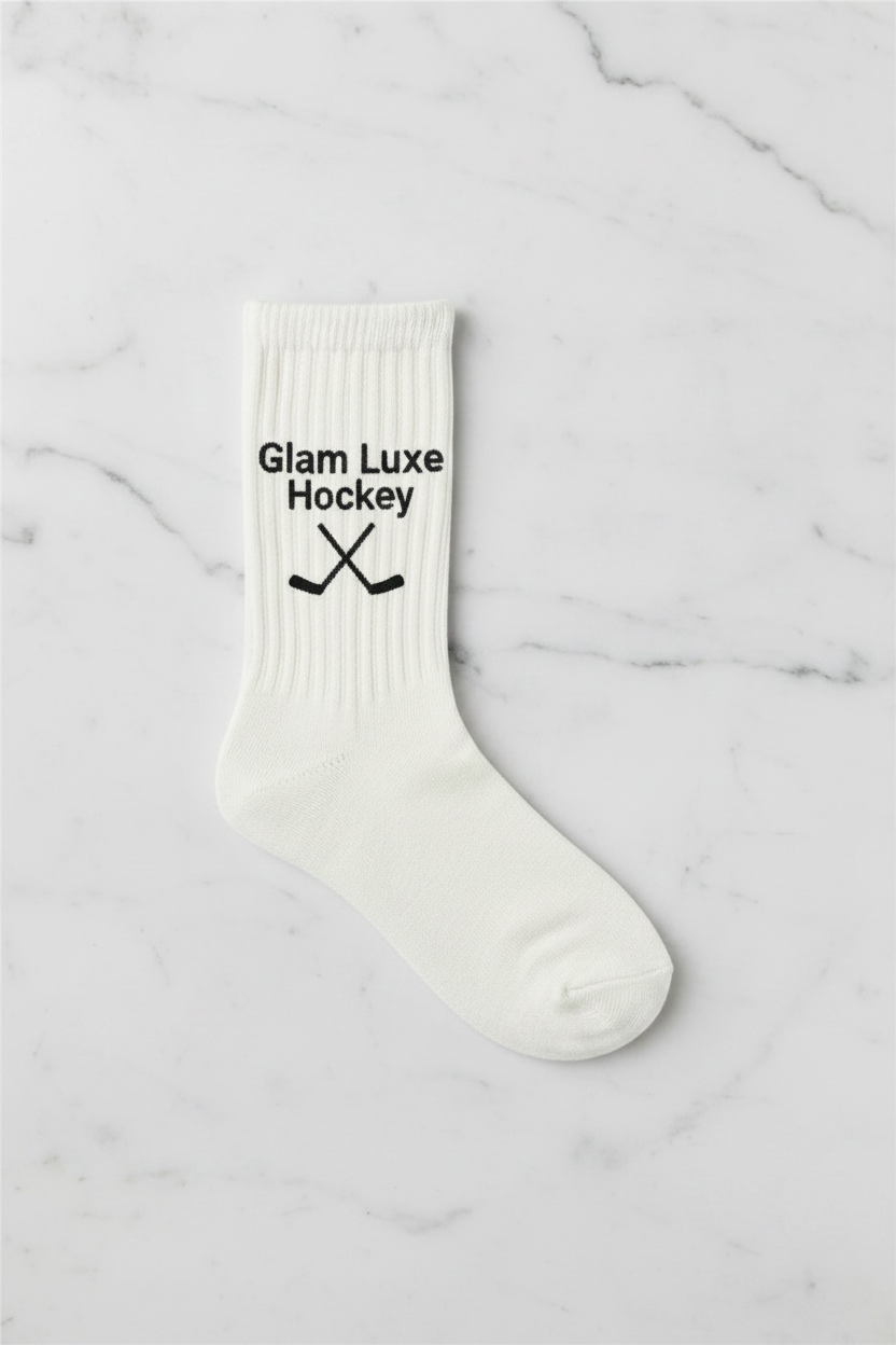 A single white crew sock with black Classic finishes. Glam Luxe Hockey and a black crossed hockey stick graphic, shown on a plain white background.